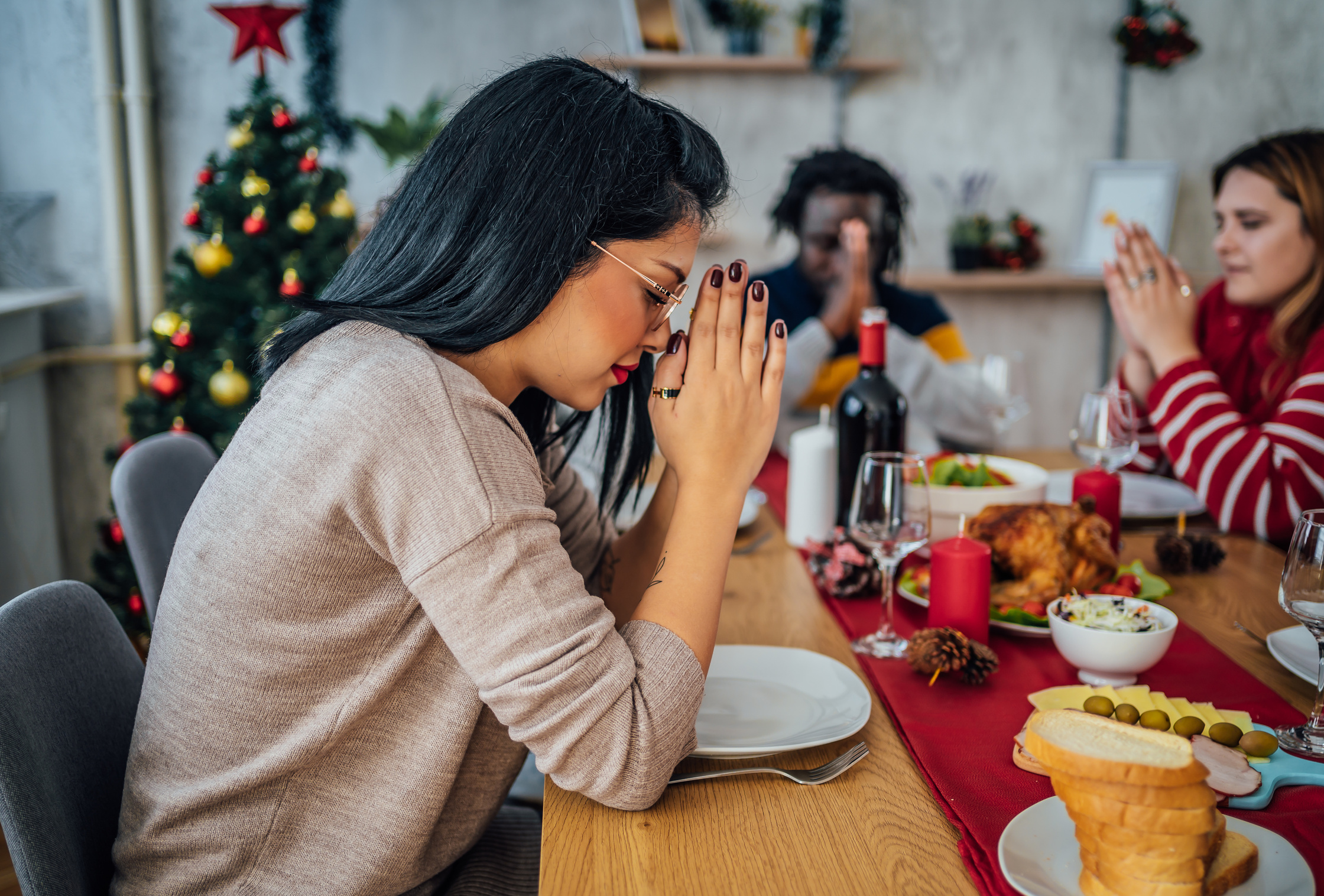 Woman praying before eating Christmas lunch